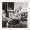 Thomas Mann, Ganzaufnahme, Profil nach links, Brille in der linken und Zigarre in der rechten Hand, im Garten sitzend, rauchend.